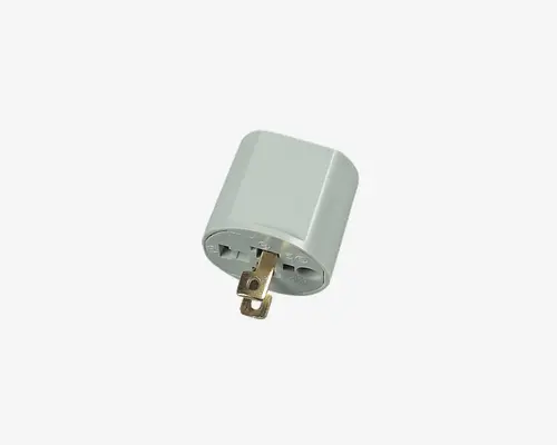 Kompakt, cylindrisk adapter med hvidt plastikhus. Den har to flade, parallelle ben og én rund jordben til tilslutning i et standard nordamerikansk stik. Fronten har universelle stikindgange, der passer til forskellige stiktyper fra flere lande. Adapteren er let og nem at tage med på rejser.