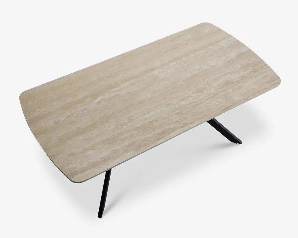 Rektangulær bordplade med en lys beige, marmorlignende finish og diskrete naturlige årer. Overfladen har blødt afrundede hjørner og står på skråtstillede sorte metalben, hvilket giver et moderne og minimalistisk udtryk.