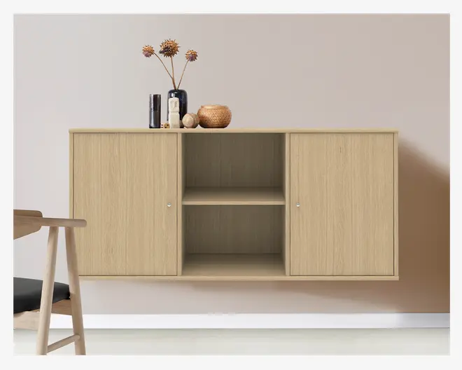 Rektangulært væghængt skab i lyst træ med naturlig træstruktur. Skabet har to lukkede rum med låger i hver side og to åbne hylder i midten. Det har et minimalistisk design med små runde metalgreb på lågerne. Ovenpå skabet står dekorative genstande, herunder vaser og en flettet kurv.