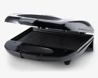 Kompakt elektrisk grill med elegant sort finish, hængslet låg og non-stick rillet stegeflade til grillning. Grillen har et skråt design, der leder fedt væk, samt en aftagelig drypbakke for nem rengøring. Håndtaget er bredt og ergonomisk for sikker åbning og lukning.