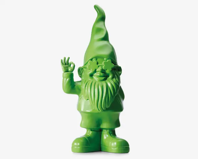 Dekorativ figur i klar grøn farve formet som en nisse med høj, spids hue, langt struktureret skæg og et muntert udtryk. Nissen vinker med højre hånd, og øjnene er formet som stjerner. Overfladen er blank, hvilket giver et moderne og legende ud best.