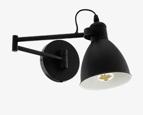 Væghængt lampe i mat sort med justerbar arm og konisk skærm. Lampen har en rund vægplade og en synlig ledning øverst. Skærmens inderside er hvid, hvilket giver bedre lysrefleksion. Armen kan justeres, så lampen nemt kan rettes efter behov, hvilket gør den velegnet som arbejds- eller læselampe.