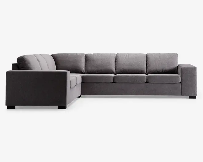 Moderne L-formet hjørnesofa med venstrevendt chaiselong, polstret i mørkegråt stof. Sofaen har brede, firkantede armlæn, tykke sædehynder og bløde ryghynder for ekstra komfort. Designet er minimalistisk med rene linjer, velegnet til moderne stuer.