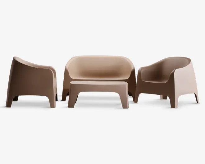 Sæt med moderne, minimalistiske siddepladsmøbler i en lys beige farve, bestående af to lænestole og en to-personers sofa. Hvert møbel har en glat, mat overflade med blødt buede ryg- og armlæn samt brede, stabile ben. Designet er sømløst og støbt i ét stykke materiale, hvilket giver et nutidigt udtryk, der egner sig til både indendørs og udendørs brug.