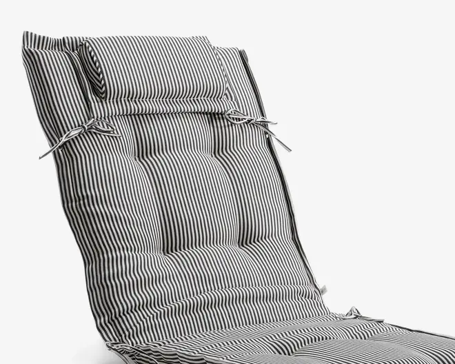 Hyndefyld med sort-hvidt lodret stribemønster, polstret hovedpude fastgjort med stofbånd. Hynden er quiltet for ekstra komfort og har yderligere bånd i siderne til fastgørelse på en stol. Stoffet ser blødt ud, og polstringen er tyk, hvilket giver støtte til både ryg og sæde.