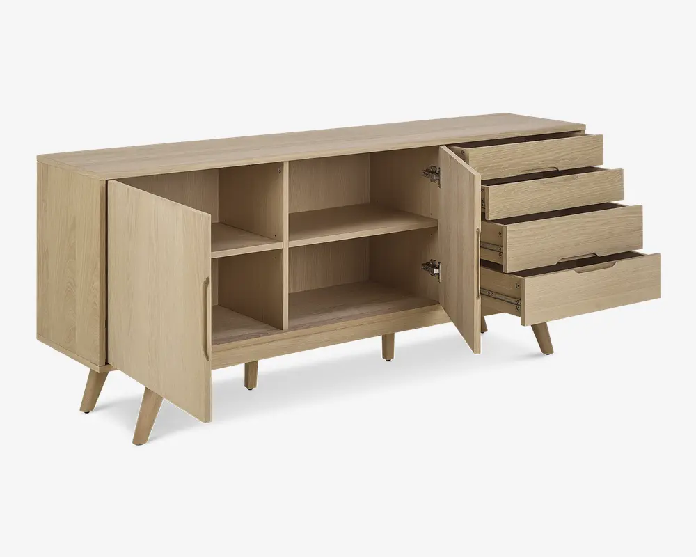 Skænk i lyst træ med skrå ben, to låger til venstre der åbner op til to rummelige hylder, og tre skuffer til højre med indbyggede greb. Designet er minimalistisk og moderne med glatte overflader og rene linjer.