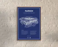 En indrammet plakat med en blueprint-lignende illustration af et stadion, tegnet med detaljerede hvide linjer på en dyb blå baggrund. Øverst på plakaten står 'PARKEN' med store hvide bogstaver, og derunder er der yderligere information om sted og datoer. Nederst er der tekstblokke og et citat, alt sammen i hvidt, med et rent og moderne layout. Rammen er slank og i lyst træ, og plakaten hænger på en lys murstensvæg.
