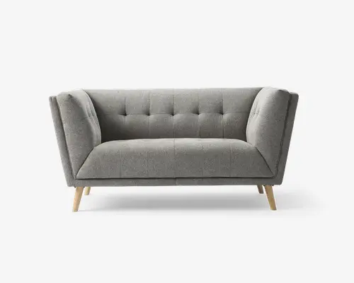 Moderne sofa med lysegråt stofbetræk, der har knapdetaljer på ryglæn og sæde for ekstra struktur. Armlænene er vinklet udad, hvilket giver et moderne udtryk. Sofaen står på fire lyse træben, der er let skråtstillede og understreger det stilrene og minimalistiske design.