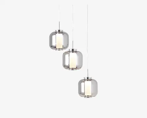 Sæt med tre pendellamper med klare, afrundede glasskærme og cylindriske indre diffusorer. Hver lampe hænger i forskellig højde fra en slank, lige ledning, hvilket skaber et forskudt arrangement. Glasskærmene har et moderne, minimalistisk design, og de indvendige diffusorer giver et blødt, jævnt lys. Det samlede udtryk er moderne og elegant, velegnet til nutidige indretninger.