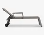 Elegant og moderne udendørs liggestol med justerbar ryglæn, så du kan tilpasse liggepositionen. Stellet er lavet af robust metal med mat finish og har to hjul i den ene ende for nem flytning. Stolen har integrerede armlæn og et strømlinet design, velegnet til brug ved poolen eller på terrassen.