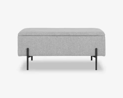 Rektangulær bænk med lys grå polstret pude og korpus. Bænken har et minimalistisk design med rene linjer og er understøttet af en sort metalramme med afrundede ben og en base, der danner en sammenhængende løkke. Det samlede udtryk er moderne og stilrent, velegnet til nutidige indretninger.