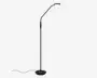 Høj, slank standerlampe med mat sort finish og en rund, stabil fod. Lampen har en justerbar arm med flere led, hvilket giver fleksibel placering af lyset. Lampeskærmen er rund og udsender et blødt, varmt lys, ideelt til læsning eller arbejdsbelysning. Strømledningen går ud fra bunden for nem tilslutning.