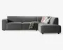 Moderne hjørnesofa med højrevendt chaiselong, betrukket med mørkegråt stof. Sofaen har brede, firkantede armlæn og dybe, bløde sædehynder for ekstra komfort. Der medfølger to pyntepuder—en med stribet mønster og en ensfarvet hvid—samt et tekstureret tæppe, der er lagt over chaiselongen. Sofaen har et lavt design og står på korte, solide ben.