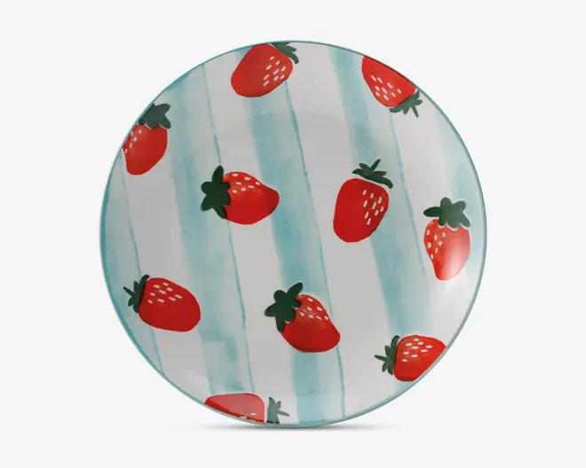 Rund tallerken med et legende design, hvor klare røde jordbær er spredt ud over overfladen. Baggrunden har bløde, lodrette aqua-blå striber, hvilket giver et frisk og muntert udtryk. Jordbærrene er illustreret med grønne blade og hvide frø, hvilket tilføjer et fantasifuldt præg.