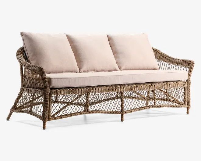 Tremandssofa med stel af naturligt flettet rattan, der har let buede armlæn og et dekorativt gittermønster langs bund og sider. Sofaen har tre store, bløde beige ryghynder og en tyk, matchende siddehynde for ekstra komfort. Designet kombinerer en solid konstruktion med et let og luftigt udtryk, velegnet til både indendørs og udendørs brug.