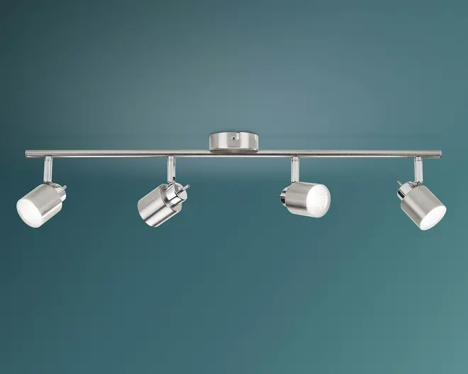 Loftlampe i børstet metal med en lige vandret stang, rund midterkappe og fire justerbare cylindriske spotlamper på en teal baggrund.