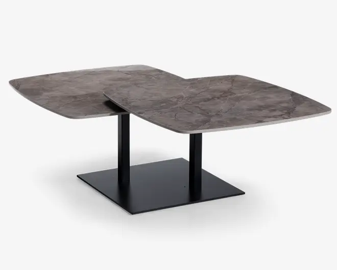 Moderne bord med to overlappende, kvadratiske bordplader med marmorlignende finish i brune og grå nuancer. Bordpladerne understøttes af to lodrette sorte metalben, der er fastgjort til en solid, flad rektangulær base, hvilket giver stabilitet og et moderne udtryk. Kanterne på bordpladerne er let buede, hvilket tilføjer et blødt og elegant præg til det geometriske design.