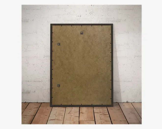 Billedet viser bagsiden af en rektangulær ramme med en brun MDF-bagside. Rammen har en sort kant og er udstyret med tre metalophæng—et i midten foroven og to på siderne, hvilket giver fleksible ophængningsmuligheder. Bagsiden holdes fast til rammen med flere sorte klips, der er jævnt fordelt langs kanterne.