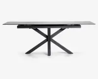 Rektangulært bord med en elegant, mat sort finish. Bordpladen ser ud til at være lavet af et solidt materiale og understøttes af et karakteristisk krydset benstel, som giver både stabilitet og et moderne udtryk. Bordet har rene linjer og et minimalistisk design, der passer til moderne indretning.