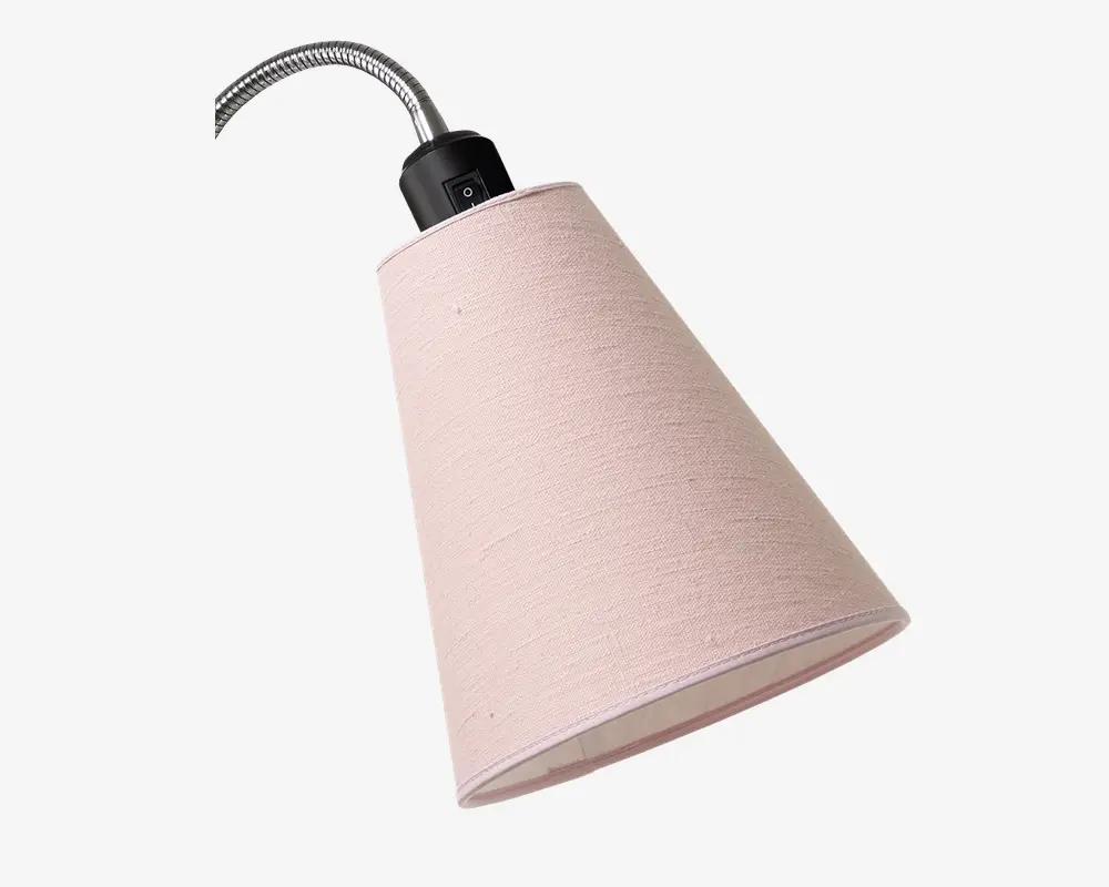 En konisk lampeskærm lavet af lyserødt stof med en diskret tekstur. Skærmen er monteret på en fleksibel, sølvfarvet svanehals og har en sort plastbeslag øverst med en synlig tænd/sluk-knap. Det samlede design er enkelt og moderne, velegnet til forskellige indretninger.