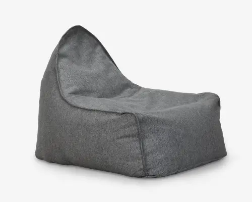 Blød loungestol i gråt stof med høj ryg og bredt, lavt sæde. Stolen har en afslappet, poset form med synlige syninger langs kanterne, hvilket giver et uformelt og komfortabelt udtryk. Stoffet har en diskret tekstur, og designet er moderne og minimalistisk.