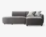 Moderne hjørnesofa med lav profil, betrukket med blødt, mørkegråt stof. Sofaen har en venstrevendt chaiselong og et højrevendt sæde med lige armlæn. Der medfølger to pyntepuder: én med smalle sorte og hvide striber og én med brede grå og hvide striber. Sofaen har rene linjer og et minimalistisk udtryk, understøttet af korte, solide ben.