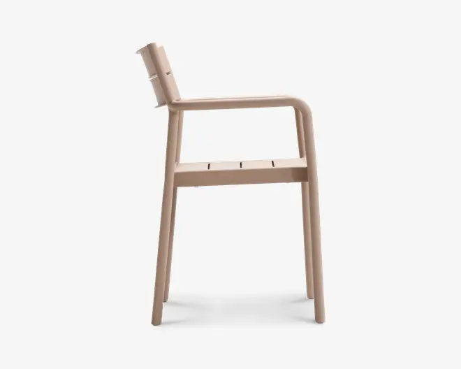 Sideprofil af en moderne stol med minimalistisk design, let tilbagelænet ryglæn, integrerede armlæn og fladt sæde med diskrete slidser for ventilation. Stolen er lavet af et glat, mat materiale i en lys beige farve og har blødt afrundede kanter for et moderne udtryk.