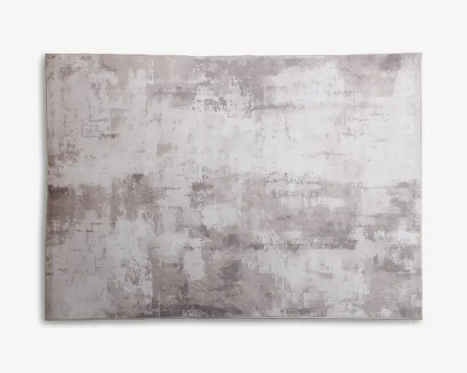 Rektangulært tæppe med et moderne abstrakt mønster i lysegrå og beige nuancer. Designet har et slidt, tekstureret udseende, hvilket giver det et moderne og alsidigt look, der passer til forskellige indretninger. Overfladen ser blød og glat ud med diskrete farvevariationer over hele tæppet.