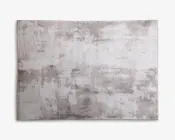 Rektangulært tæppe med et moderne abstrakt mønster i lysegrå og beige nuancer. Designet har et slidt, tekstureret udseende, hvilket giver det et moderne og alsidigt look, der passer til forskellige indretninger. Overfladen ser blød og glat ud med diskrete farvevariationer over hele tæppet.