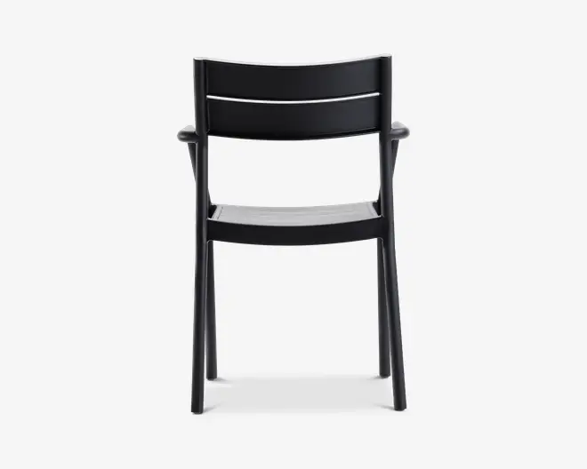 En sort stol med et minimalistisk design, der har en let buet ryglæn med to vandrette lameller for støtte. Sædet er også let formet for komfort. Stolen har lige ben og integrerede armlæn, der går ud fra ryglænet. Det samlede udtryk er moderne og funktionelt, velegnet til både indendørs og udendørs brug.