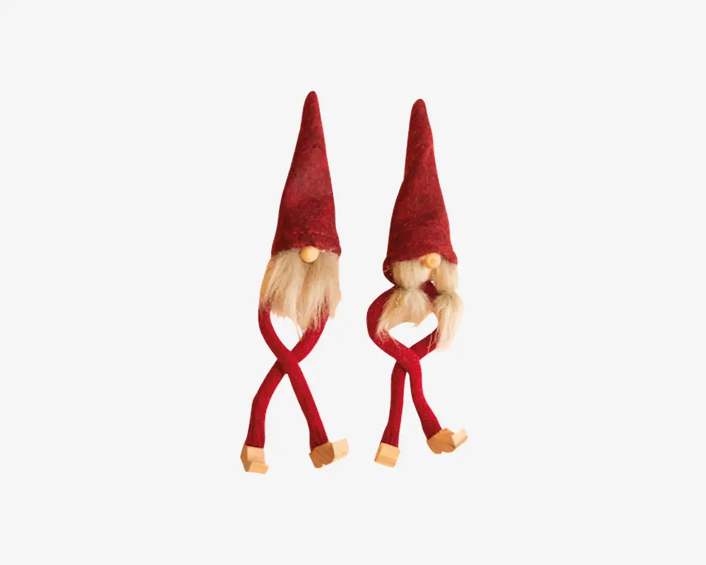 To dekorative figurer med høje, spidse røde hatte, lange hvide skæg og runde trænæser. Hver figur har lange, bøjelige røde ben og beige sko. Den ene figur har et lige skæg, mens den anden har to fletninger. Begge har et finurligt, håndlavet udtryk.