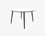 Et rundt bord med en glat, hvid bordplade og fire slanke, sorte metalben, der er let skråtstillede for stabilitet. Designet er minimalistisk og moderne med en tynd bordplade og et rent, enkelt udtryk.