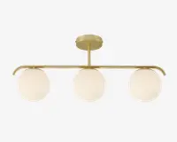 Moderne loftlampe med tre jævnt fordelte, runde kugler af mat glas, monteret på en slank, vandret metalstang i guld. Stangen er fastgjort til en matchende rund loftplade i guld med en kort, lodret stang. Designet er minimalistisk og elegant, velegnet til moderne indretning.