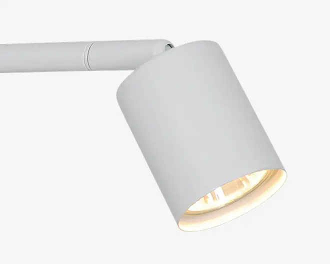 Hvid justerbar spotlight med cylindrisk skærm monteret på en slank vandret arm, vinklet nedad med en varm lyskilde indeni.