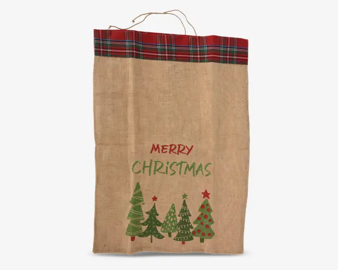 Rektangulær stofpose med naturlig jutestruktur, rød og grøn ternet kant øverst samt matchende håndtag. Forsiden er dekoreret med teksten 'Merry Christmas' i rød og grøn samt illustrationer af fem stiliserede juletræer i forskellige grønne nuancer, nogle med røde kugler og stjerner.