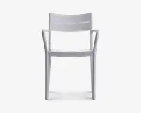 Moderne stol med et minimalistisk design i en ensfarvet hvid. Stolen har et let buet ryglæn for ergonomisk støtte og integrerede armlæn, der glider elegant ud fra benene. Sædet er fladt, og hele konstruktionen er lavet i ét støbt stykke, hvilket giver et stilrent og sammenhængende udtryk. Benene er lige og robuste, velegnet til både indendørs og udendørs brug.