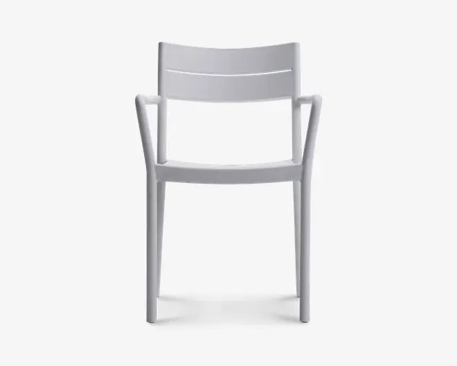 Moderne stol med et minimalistisk design i en ensfarvet hvid. Stolen har et let buet ryglæn for ergonomisk støtte og integrerede armlæn, der glider elegant ud fra benene. Sædet er fladt, og hele konstruktionen er lavet i ét støbt stykke, hvilket giver et stilrent og sammenhængende udtryk. Benene er lige og robuste, velegnet til både indendørs og udendørs brug.