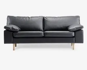 En moderne sort lædersofa med to store sædehynder og to bløde ryghynder. Armlænene er brede og let skrå, hvilket giver ekstra komfort. Sofaen står på fire lyse træben, hvilket giver et moderne og let udtryk.