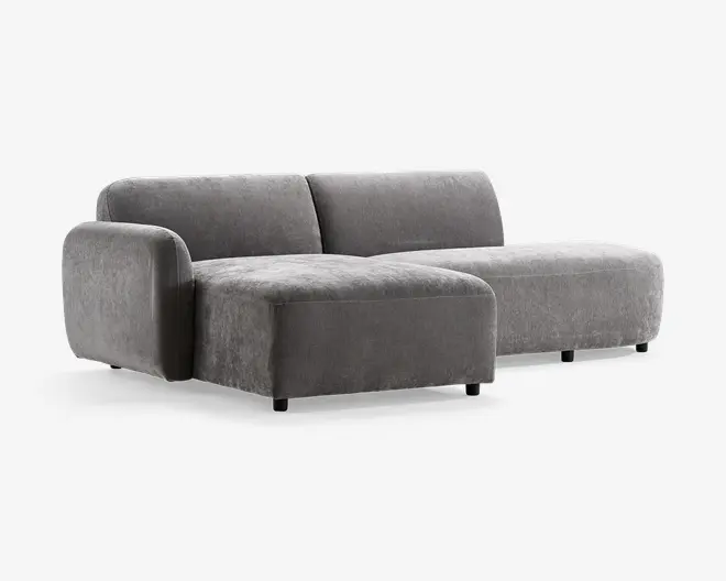 Moderne hjørnesofa med lav profil og blød, velouragtig grå polstring. Har armlæn på venstre side, bredt siddeområde og dybe puder for ekstra komfort. Sofaen har rene linjer og et minimalistisk design, understøttet af korte, solide ben. Perfekt til moderne stuer.