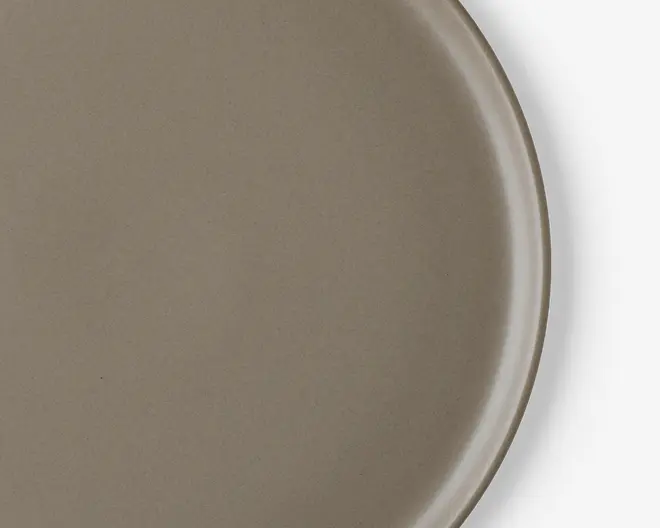 Rund tallerken med en glat, mat taupe-finish og en let forhøjet kant. Overfladen er jævn og uden tekstur, hvilket giver et minimalistisk og moderne udtryk.