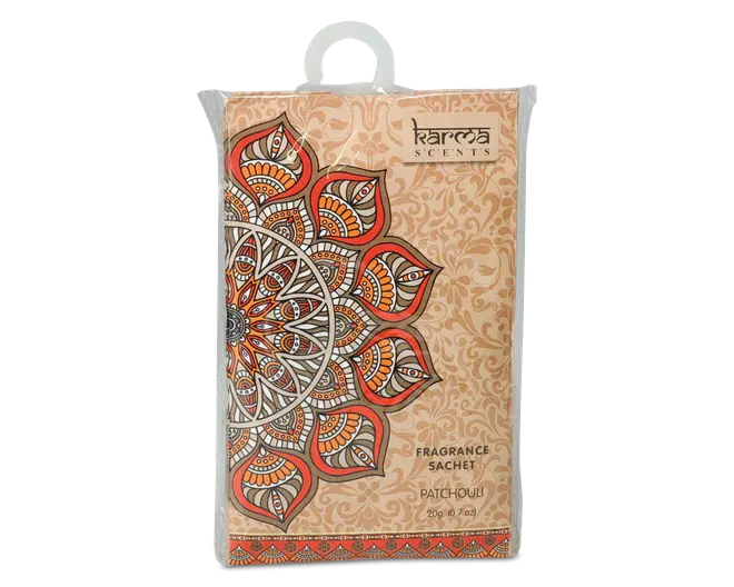 Rektangulær pose med et dekorativt mandala-mønster i orange, brune og hvide nuancer på en beige baggrund. Emballagen har detaljerede mønstre og et gennemsigtigt plastlag med en ophængningsløkke øverst. Etiket viser, at duften er patchouli og angiver vægten som 20g (0,7oz).