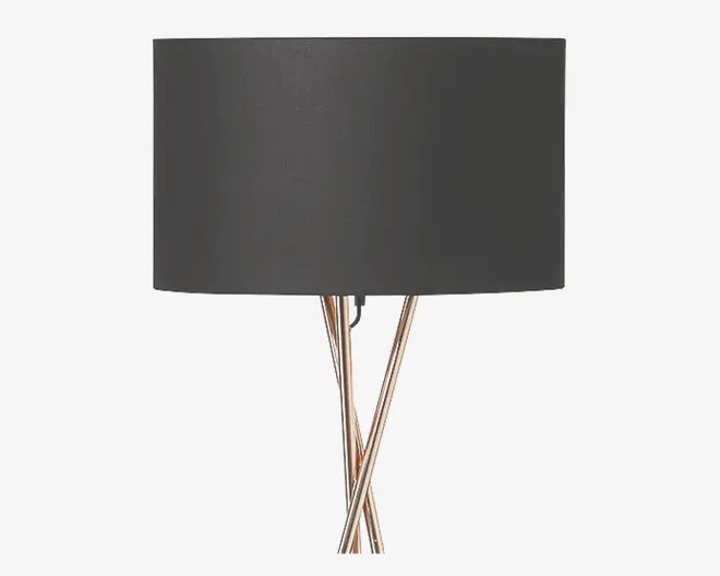 En moderne bordlampe med en stor, cylindrisk sort lampeskærm og en fod bestående af tre slanke, metalstænger, der krydser hinanden i et elegant, flettet design. Foden har en blank, kromlignende overflade, hvilket giver lampen et moderne og stilfuldt udtryk.
