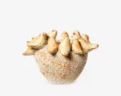 Dekorativ keramikskål med en tekstureret, porøs overflade, der ligner natursten. Skålens kant er udsmykket med otte skulpturelle fugle, hver med en blank beige og lysebrun finish, hvilket giver et håndlavet og kunstnerisk udtryk. Fuglene sidder som om de hviler på kanten, hvilket tilføjer et finurligt og naturinspireret præg.