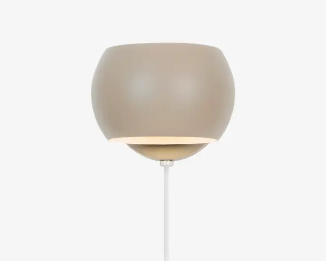 En moderne væglampe med en glat, rund skærm i mat beige. Lampen har et minimalistisk design, hvor lyset rettes nedad fra den åbne bund af skærmen. Den er monteret med en hvid ledning, der går ud fra bunden, og det samlede udtryk er stilrent og nutidigt, hvilket passer til mange forskellige indretninger.