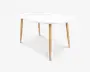 Hvid oval bordplade med fire tilspidsede ben i lyst træ og et rent, minimalistisk design.