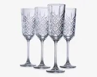 Sæt med fire klare glasfløjter med lange stilke og et dekorativt diamantmønster på skålen, hvilket giver et tekstureret og elegant udseende. Glassene har en slank form, der er velegnet til servering af mousserende drikke.