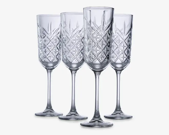 Sæt med fire klare glasfløjter med lange stilke og et dekorativt diamantmønster på skålen, hvilket giver et tekstureret og elegant udseende. Glassene har en slank form, der er velegnet til servering af mousserende drikke.