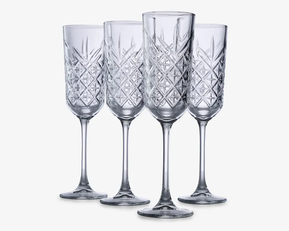 Sæt med fire klare glasfløjter med lange stilke og et dekorativt diamantmønster på skålen, hvilket giver et tekstureret og elegant udseende. Glassene har en slank form, der er velegnet til servering af mousserende drikke.