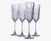 Sæt med fire klare glasfløjter med lange stilke og et dekorativt diamantmønster på skålen, hvilket giver et tekstureret og elegant udseende. Glassene har en slank form, der er velegnet til servering af mousserende drikke.