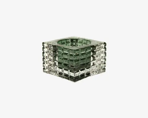 Firkantet glasbeholder med et geometrisk, gitterlignende mønster på alle sider. Glasset er klart med et let grønt skær, og den indvendige del er cylindrisk, beregnet til at holde et stearinlys eller en lille genstand. Ydersiden har hævede firkantede blokke, hvilket giver et tekstureret og moderne udseende.